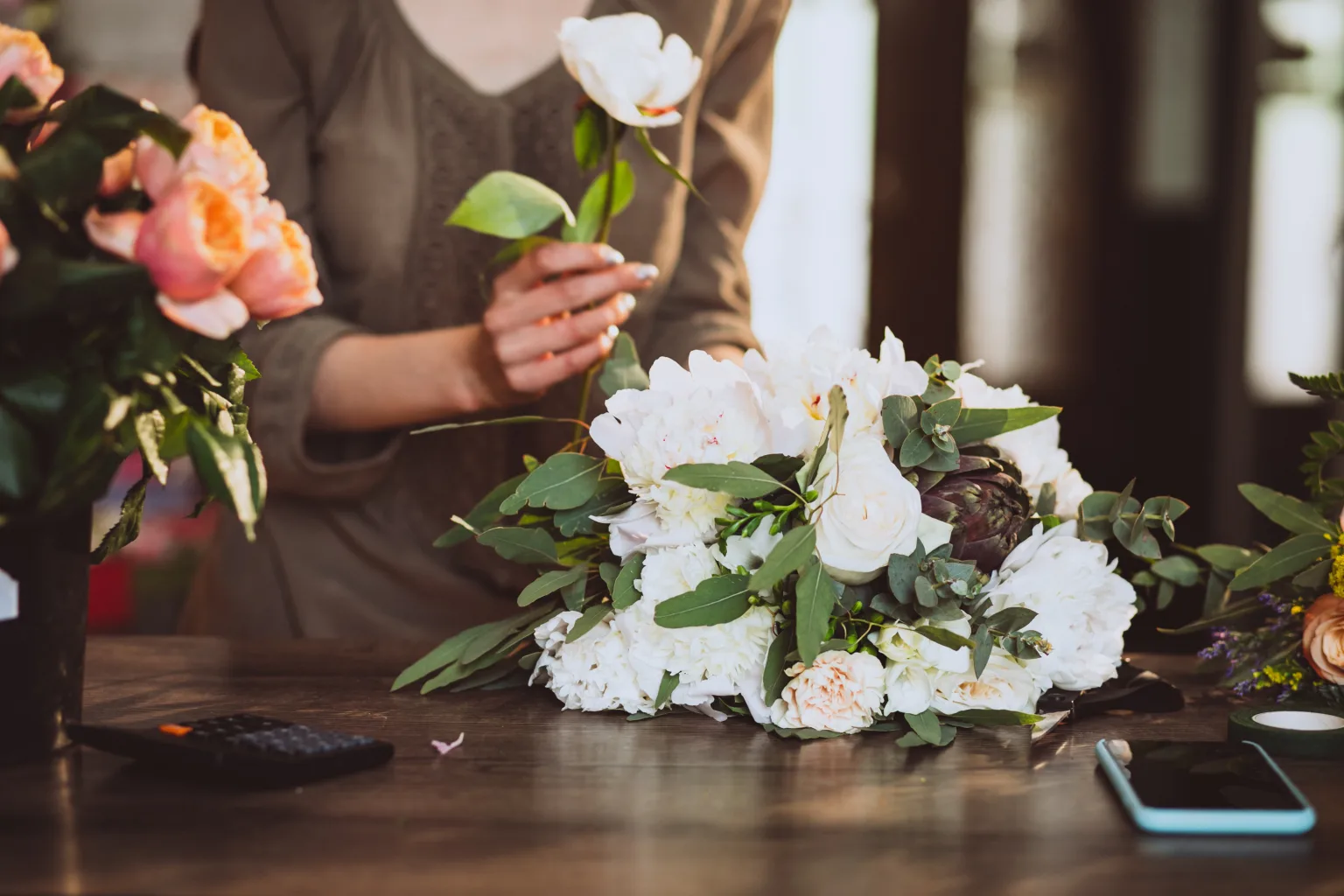 Florist at her own floral shop taking care of flowers